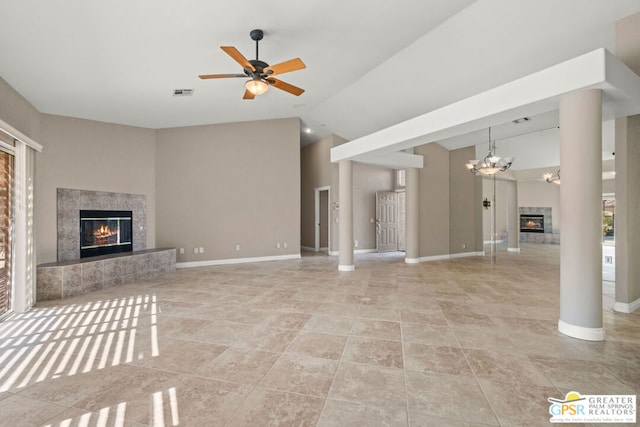 unfurnished living room featuring ceiling fan with notable chandelier and high vaulted ceiling