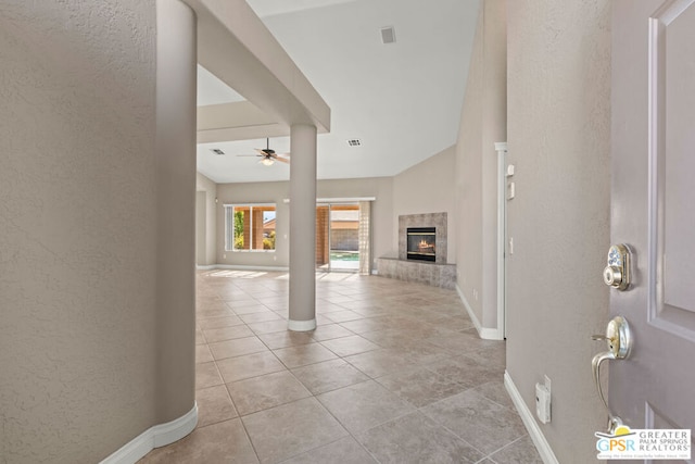 tiled foyer with ceiling fan and a tile fireplace