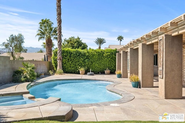 view of swimming pool featuring a patio and an in ground hot tub