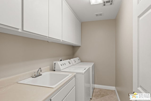 washroom featuring light tile patterned flooring, cabinets, separate washer and dryer, and sink