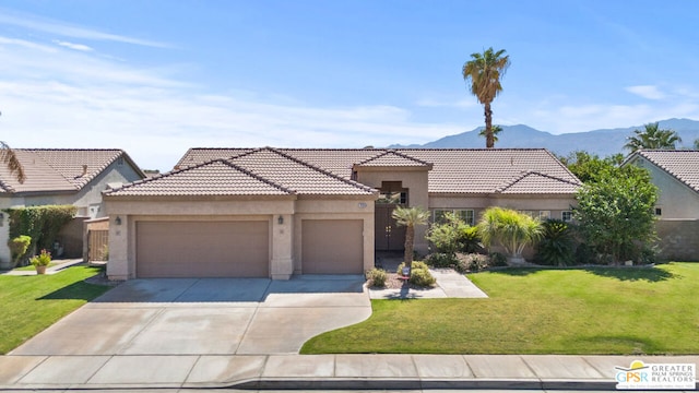 view of front facade featuring a front lawn, a mountain view, and a garage