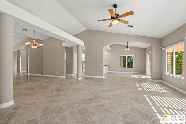 unfurnished living room with ceiling fan with notable chandelier, vaulted ceiling, light tile patterned floors, and a wealth of natural light