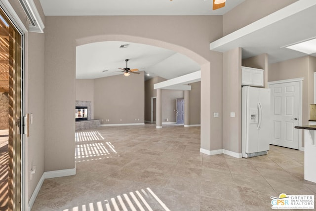 unfurnished living room featuring lofted ceiling, light tile patterned flooring, and ceiling fan