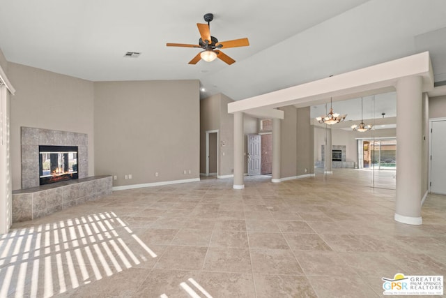 unfurnished living room with ceiling fan with notable chandelier, a multi sided fireplace, high vaulted ceiling, and light tile patterned floors