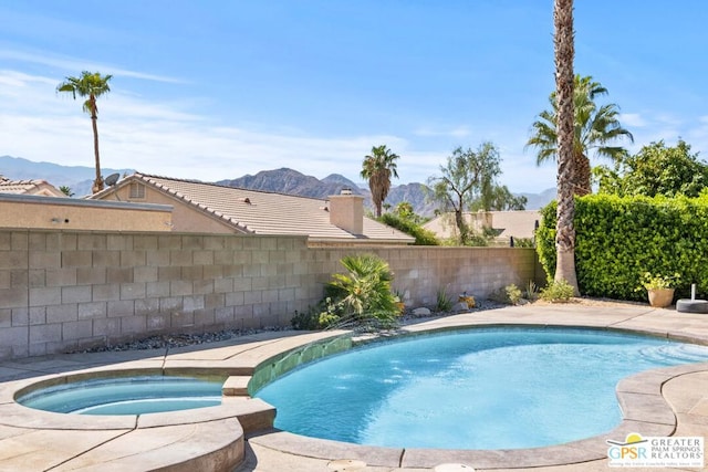 view of pool featuring a mountain view and an in ground hot tub