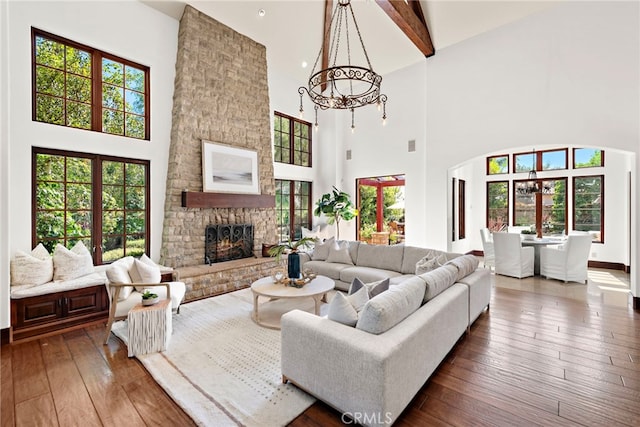 living room featuring a fireplace, beamed ceiling, dark wood-type flooring, and a high ceiling