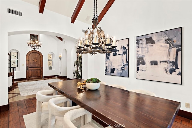 dining area featuring beam ceiling, hardwood / wood-style floors, high vaulted ceiling, and a notable chandelier