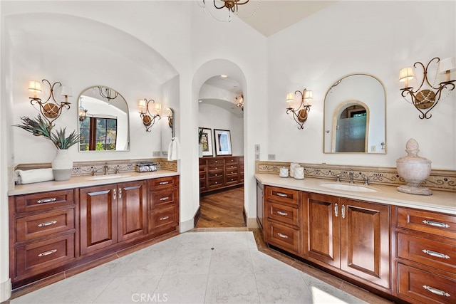 bathroom with tile patterned floors, vanity, and vaulted ceiling