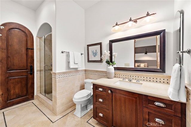 bathroom with vanity, tile walls, tile patterned flooring, toilet, and a shower with shower door