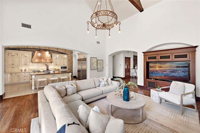 living room with hardwood / wood-style flooring, beam ceiling, and high vaulted ceiling