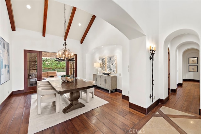 dining area featuring an inviting chandelier, dark hardwood / wood-style floors, and high vaulted ceiling