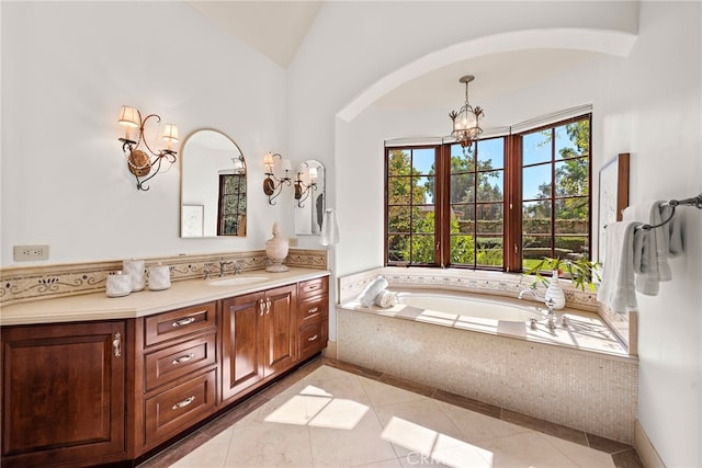 bathroom featuring vanity, lofted ceiling, tile patterned floors, tiled bath, and a chandelier