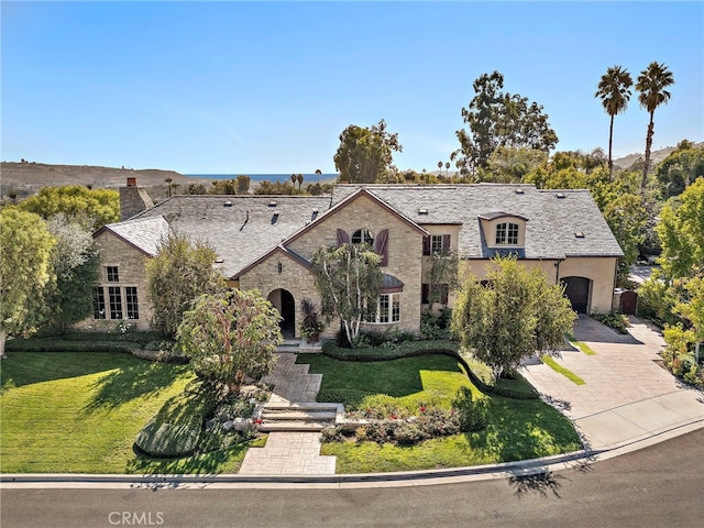 french country inspired facade with a front yard