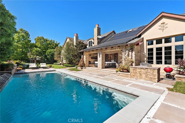 view of pool with area for grilling and a patio