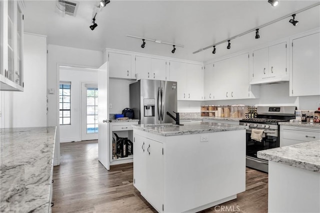 kitchen with a kitchen island, dark hardwood / wood-style flooring, track lighting, white cabinets, and appliances with stainless steel finishes