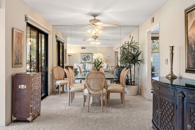 dining area featuring light carpet, a healthy amount of sunlight, and ceiling fan