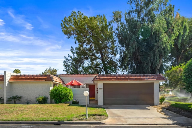 single story home featuring a garage and a front yard