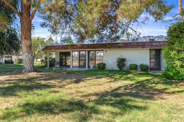 rear view of house with a yard and a patio