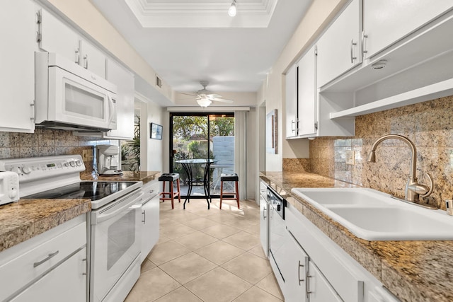 kitchen featuring white appliances, white cabinets, sink, and light tile patterned floors