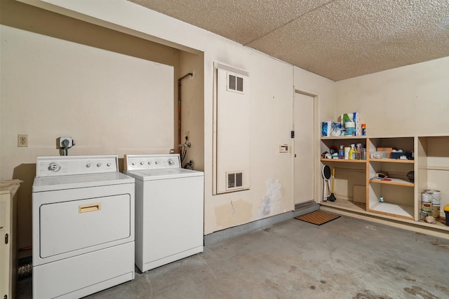 laundry room featuring a textured ceiling and washing machine and dryer