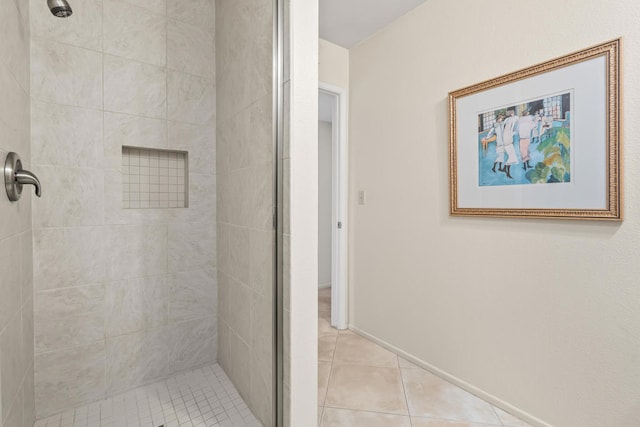 bathroom featuring tile patterned flooring and tiled shower