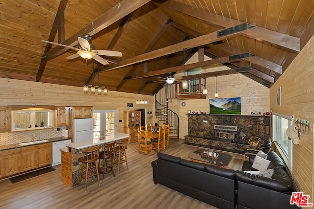 living room featuring wood walls, wooden ceiling, beam ceiling, and light hardwood / wood-style flooring