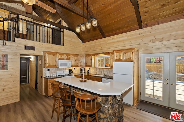 kitchen with high vaulted ceiling, wooden walls, white appliances, and french doors