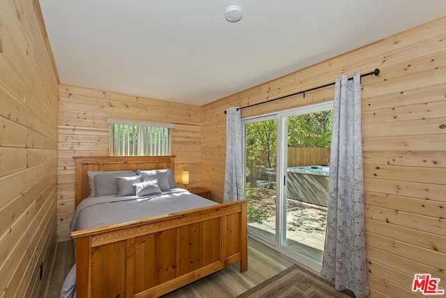 bedroom featuring wood walls and light hardwood / wood-style floors