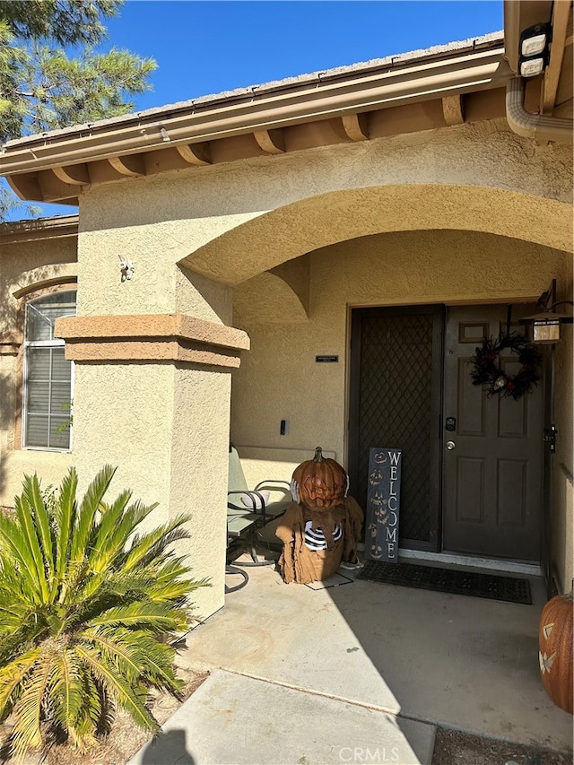 view of exterior entry with a patio area