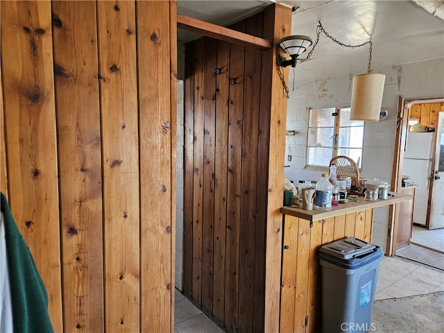 kitchen with white refrigerator and wooden walls