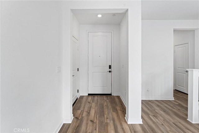 doorway to outside featuring baseboards and wood finished floors