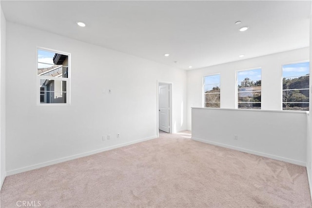 spare room with recessed lighting, carpet, baseboards, and plenty of natural light