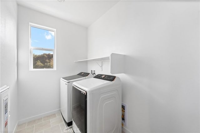 washroom with washer and dryer, baseboards, and laundry area