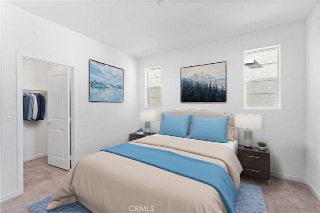 carpeted bedroom with baseboards, a closet, and a walk in closet