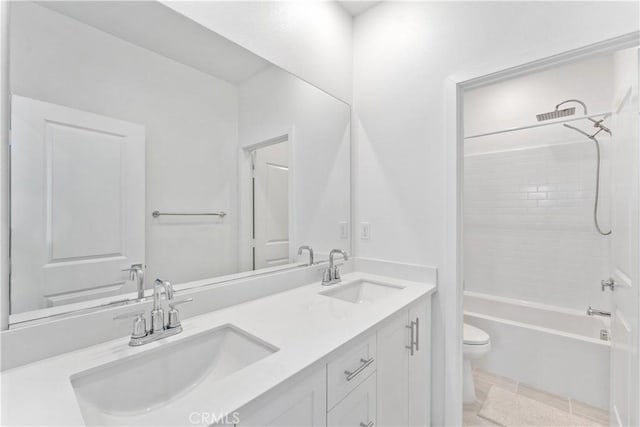 full bathroom featuring toilet, washtub / shower combination, a sink, and double vanity