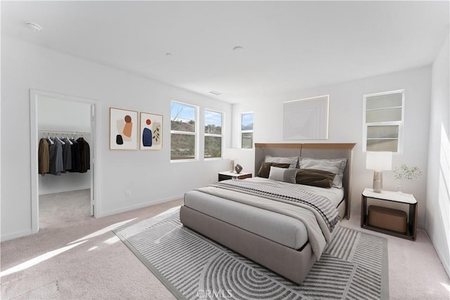 carpeted bedroom featuring baseboards, a closet, and a walk in closet