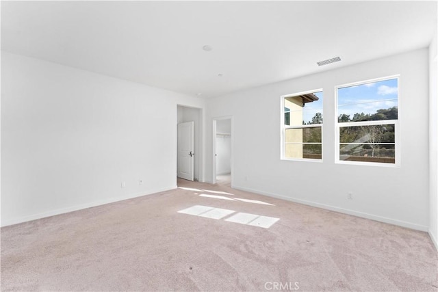 empty room with light carpet, visible vents, and baseboards