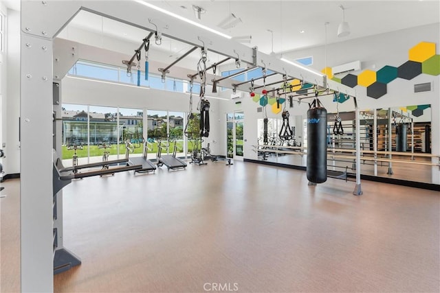 workout area featuring a towering ceiling and a wall mounted AC