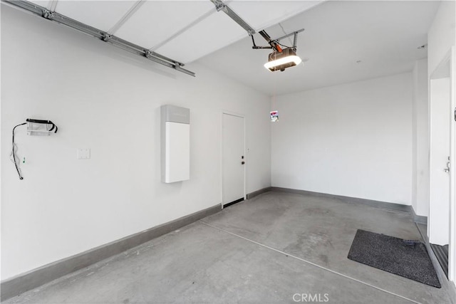 garage with baseboards and a garage door opener