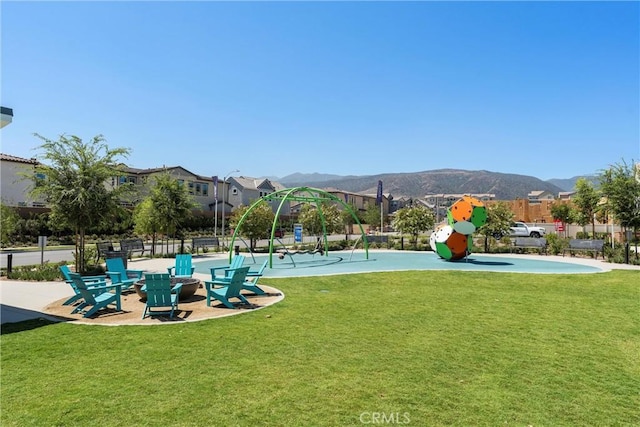 view of home's community featuring a yard, a mountain view, and playground community