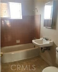 bathroom with shower / bath combination, toilet, and plenty of natural light