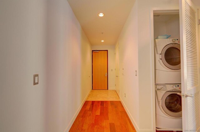 washroom with stacked washer / dryer and hardwood / wood-style floors