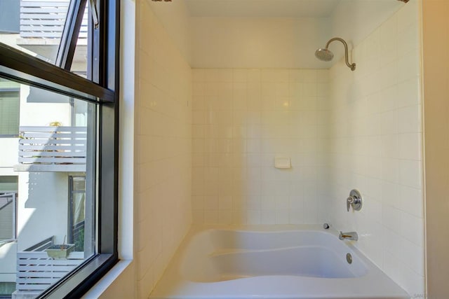 bathroom with a wealth of natural light and tiled shower / bath