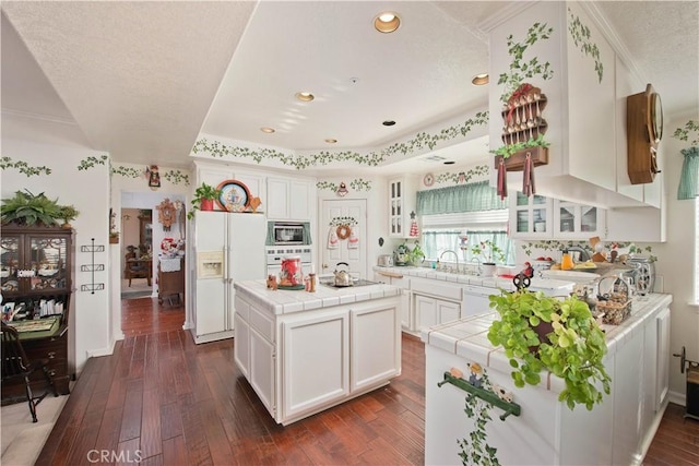 kitchen featuring tile countertops, white cabinets, white appliances, and dark wood-type flooring