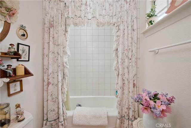 bathroom featuring shower / bath combo with shower curtain and toilet