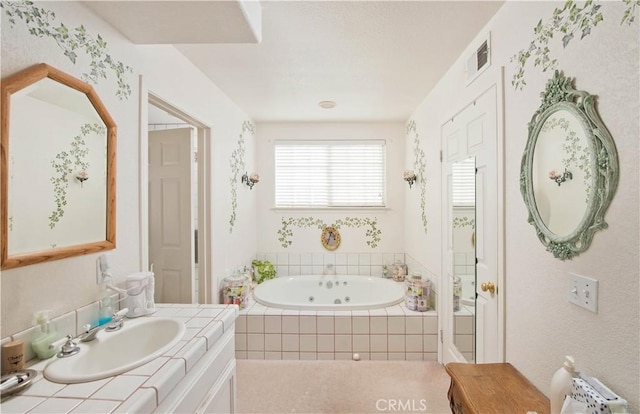 bathroom featuring vanity and tiled bath