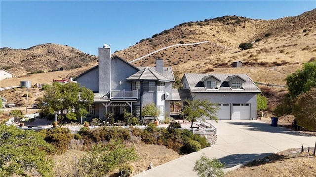 view of front of house with a mountain view, a balcony, and a garage