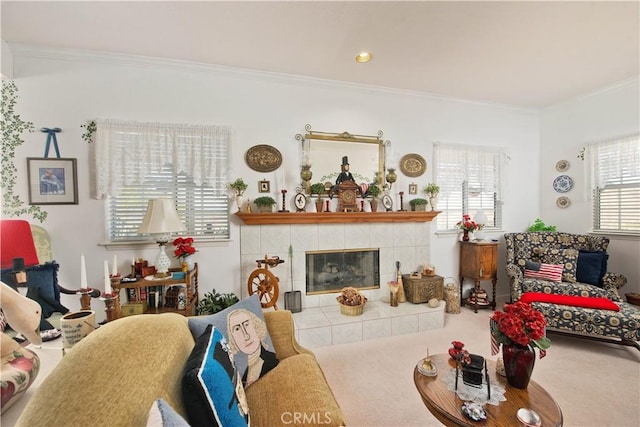 carpeted living room with a tile fireplace and crown molding