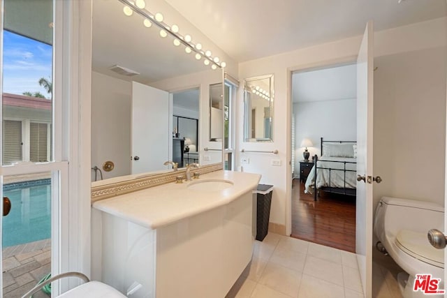 bathroom with hardwood / wood-style flooring, vanity, and toilet