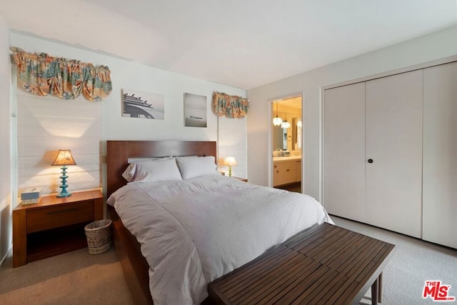 carpeted bedroom featuring ensuite bath and a closet